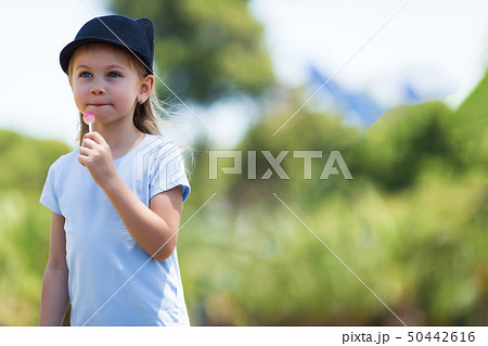 Portrait of a little charismatic girl. little girl in a headdress. girl with candy 50442616