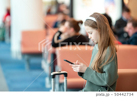 Adorable little girl at airport in big international airport near window 50442734