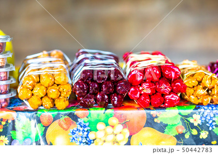 Multicolored delicious fresh Georgian Sweets Churchkhela hanging in the market 50442783