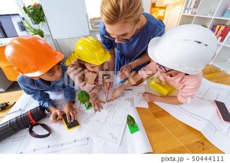 Two boys and girl wearing bright helmets drawing sketches Two boys and girl wearing bright helmets drawing sketches 50444111