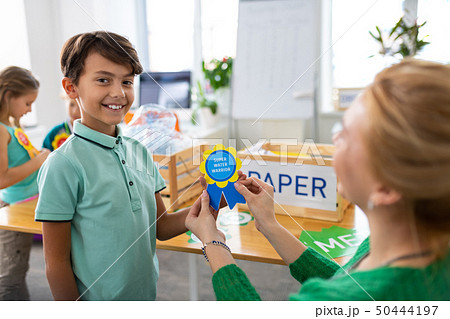 Boy feeling satisfied while getting reward at school Boy feeling satisfied while getting reward at school 50444197