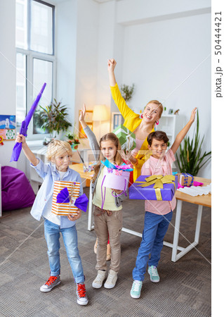 Schoolchildren standing near teacher with their boxes after art lesson 50444421