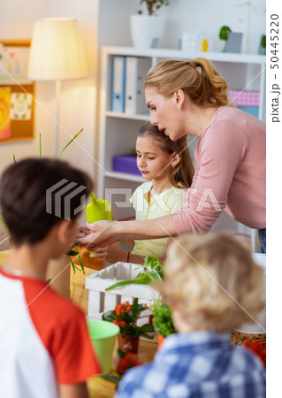 Blonde-haired teacher involving pupils into ecological campaign 50445220