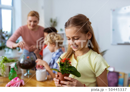 Beautiful cute girl looking at flowers while attending botany lesson 50445337
