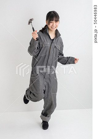 白背景スタジオ撮影作業服をきた女の子がドライバーを持って作業をしている全身工業女子 50446983