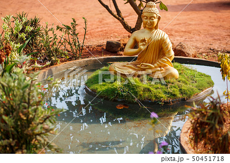 Golden buddha statue by the pond in Goa Golden buddha statue by the pond in Goa 50451718