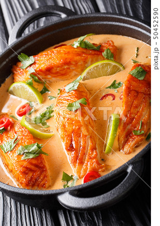 Thai spicy coconut curry with salmon close-up in a Thai spicy coconut curry with salmon close-up in a 50452590