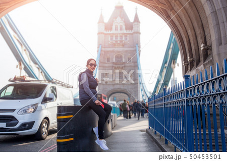 Tourist asian woman relaxing by the Tower Bridge London in summer day. Tourist asian woman relaxing by the Tower Bridge London in summer day. 50453501