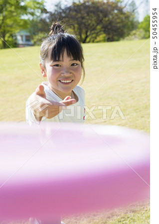 公園でフリスビーを投げる小学生女の子 公園でフリスビーを投げる小学生女の子 50455954