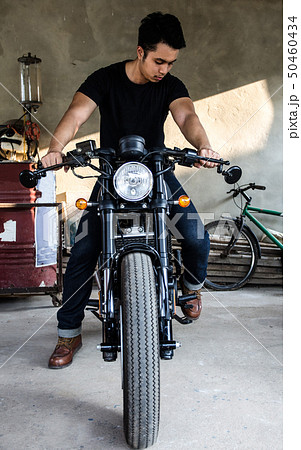 young man sitting on cafe racer motocycle young man sitting on cafe racer motocycle 50460434