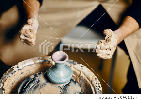 Man painting handmade pottery at ceramic workshop 50461137