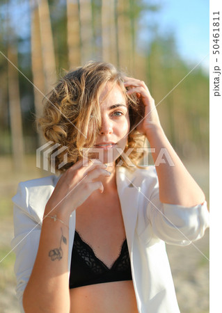 Caucasian girl with tattoo walking on sand beach and wearing white shirt. Caucasian girl with tattoo walking on sand beach and wearing white shirt. 50461811