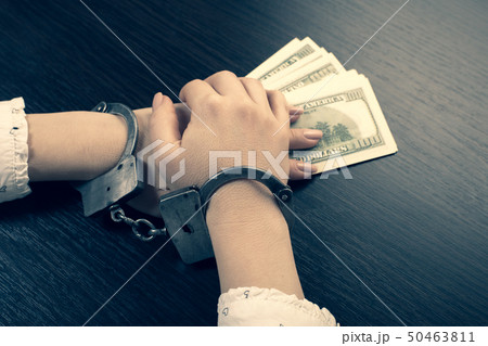hands in handcuffs holding paper money hands in handcuffs holding paper money 50463811