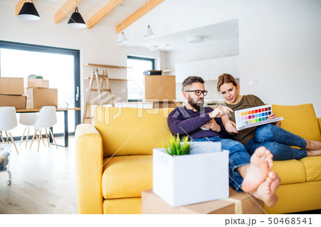 A young couple with color samples sitting on sofa, moving in new home. 50468541
