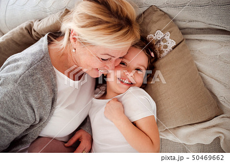 A top view portrait of small girl with grandmother having fun at home. A top view portrait of small girl with grandmother having fun at home. 50469662