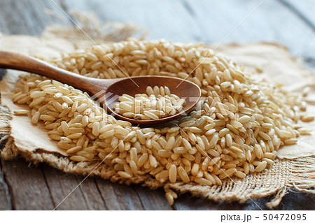 Pile of Brown rice with a wooden spoon Pile of Brown rice with a wooden spoon 50472095