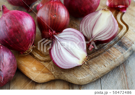 Red onions on a wooden board 50472486