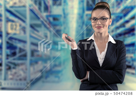 Beautiful serious business woman with glasses on futuristic empty warehouse Beautiful serious business woman with glasses on futuristic empty warehouse 50474208