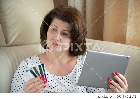 woman is upset by online shopping with a bank card woman is upset by online shopping with a bank card 50475271