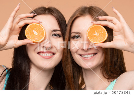 Female friends keeping fresh oranges and posing in Female friends keeping fresh oranges and posing in 50478842