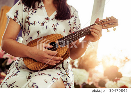 Happy woman musician playing ukulele in studio. Happy woman musician playing ukulele in studio. 50479845