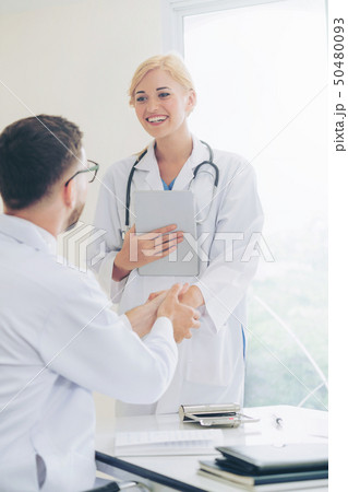 Doctor at hospital shakes hand with another doctor Doctor at hospital shakes hand with another doctor 50480093