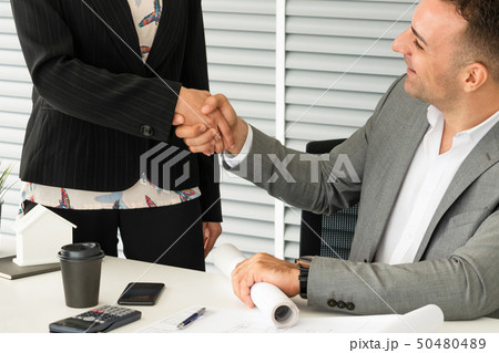 Businessman handshake businesswoman in office. Businessman handshake businesswoman in office. 50480489