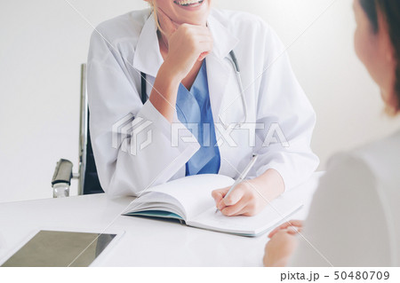 Woman Doctor and Female Patient in Hospital Office Woman Doctor and Female Patient in Hospital Office 50480709