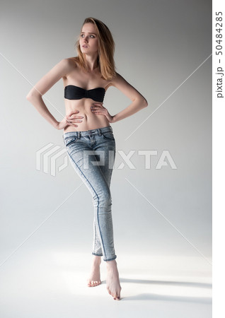 Attractive smiling woman in jeans and bra 50484285
