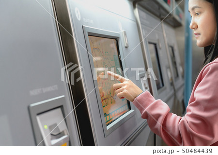 Woman choose destination on train ticket machine Woman choose destination on train ticket machine 50484439