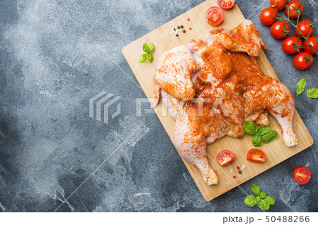 Raw chicken tobacco on a wooden Board with spices Raw chicken tobacco on a wooden Board with spices 50488266