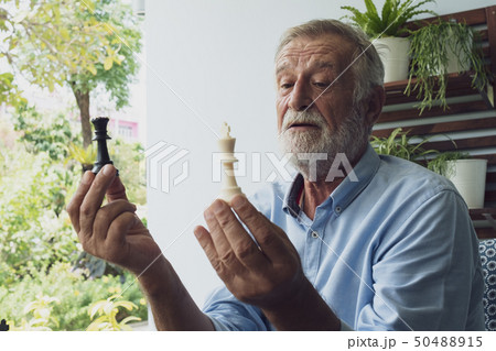 senior man happiness thinking and playing chess at senior man happiness thinking and playing chess at 50488915