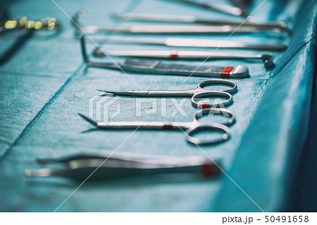 Set of sterile instruments laid out on the table for an operation on a blue cloth 50491658