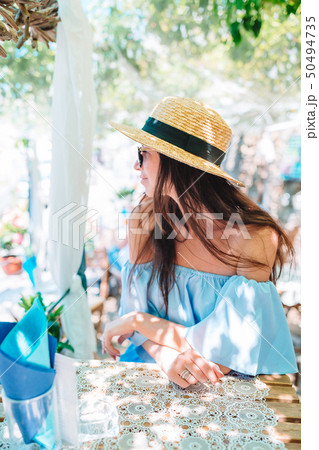 Portrait of young beautiful woman sitting in a cafe outdoor drinking coffee. Portrait of young beautiful woman sitting in a cafe outdoor drinking coffee. 50494735