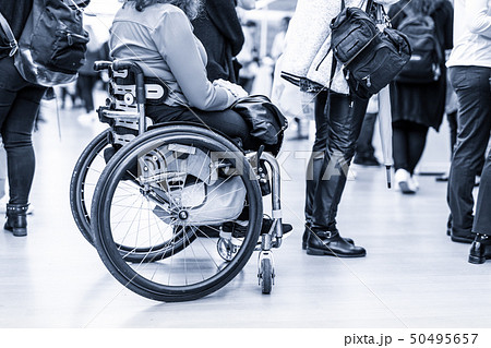 Close up of unrecognizable hanicapped woman on a wheelchair queuing in line to perform everyday Close up of unrecognizable hanicapped woman on a wheelchair queuing in line to perform everyday 50495657