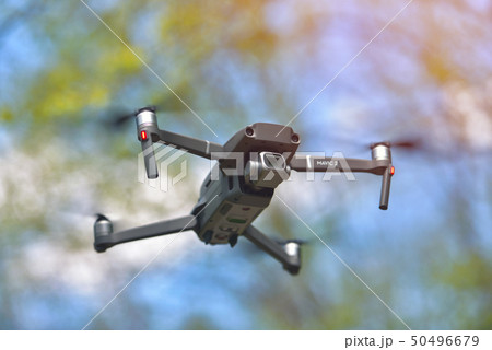 Flying drone with camera hovering inside a forrest 50496679