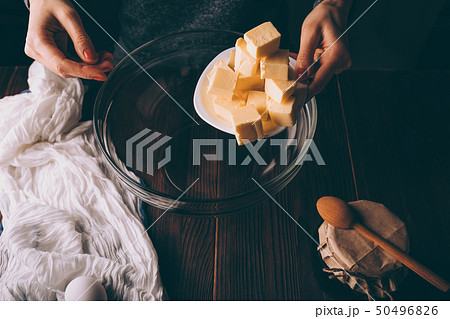 Close-up of female's hands adding diced butter 50496826