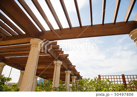Modern outdoor patio with stone floor and wooden pergola 50497806