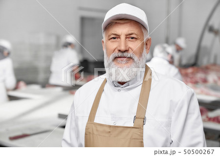 Professional butcher, elderly man in white uniform posing. Professional butcher, elderly man in white uniform posing. 50500267