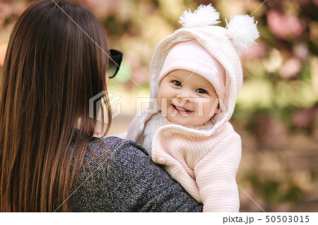 Portrait of cute little baby girl outside with mom. Beautiful girl smile. Five month baby. Happy 50503015
