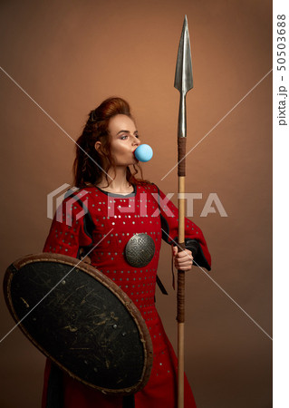 Woman warrior blowing big blue bubble gum. 50503688