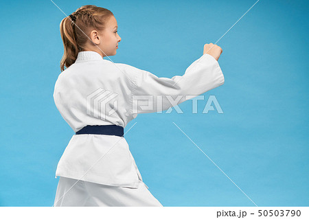 View from back of girl doing karate on isolated background 50503790