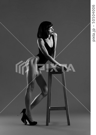 Model with short black hair leaning on chair. 50504006