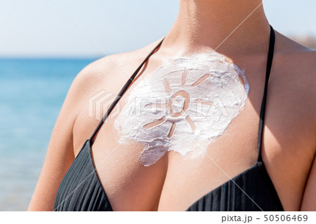 Sun shaped sunscreen on woman Sun shaped sunscreen on woman 50506469