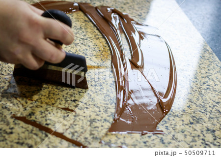 Liquid tempered chocolate applied in a thin layer 50509711