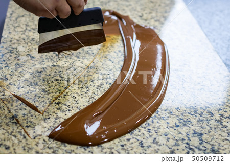 Chocolatier stirs the tempered chocolate Chocolatier stirs the tempered chocolate 50509712