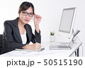 Businesswoman working at desk in busy office 50515190