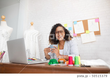 African clothing designers are drinking coffee. 50515379