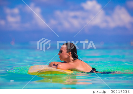 Beautiful fitness surfer woman surfing during summer vacation 50517558