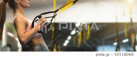 Trx training. Woman working out with fitness straps 50518068